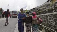 Lansia berjalan mobil bak terbuka yang menunggu saat dievakuasi dari rumah mereka di lereng Gunung Merapi, di Krinjing, Jawa Tengah, Jumat (6/11/2020). Evakuasi dilakukan bagi warga lereng Merapi menyusul peningkatan status aktivitas vulkanik gunung tersebut. (AP Photo/Taufiq Rozzaq)