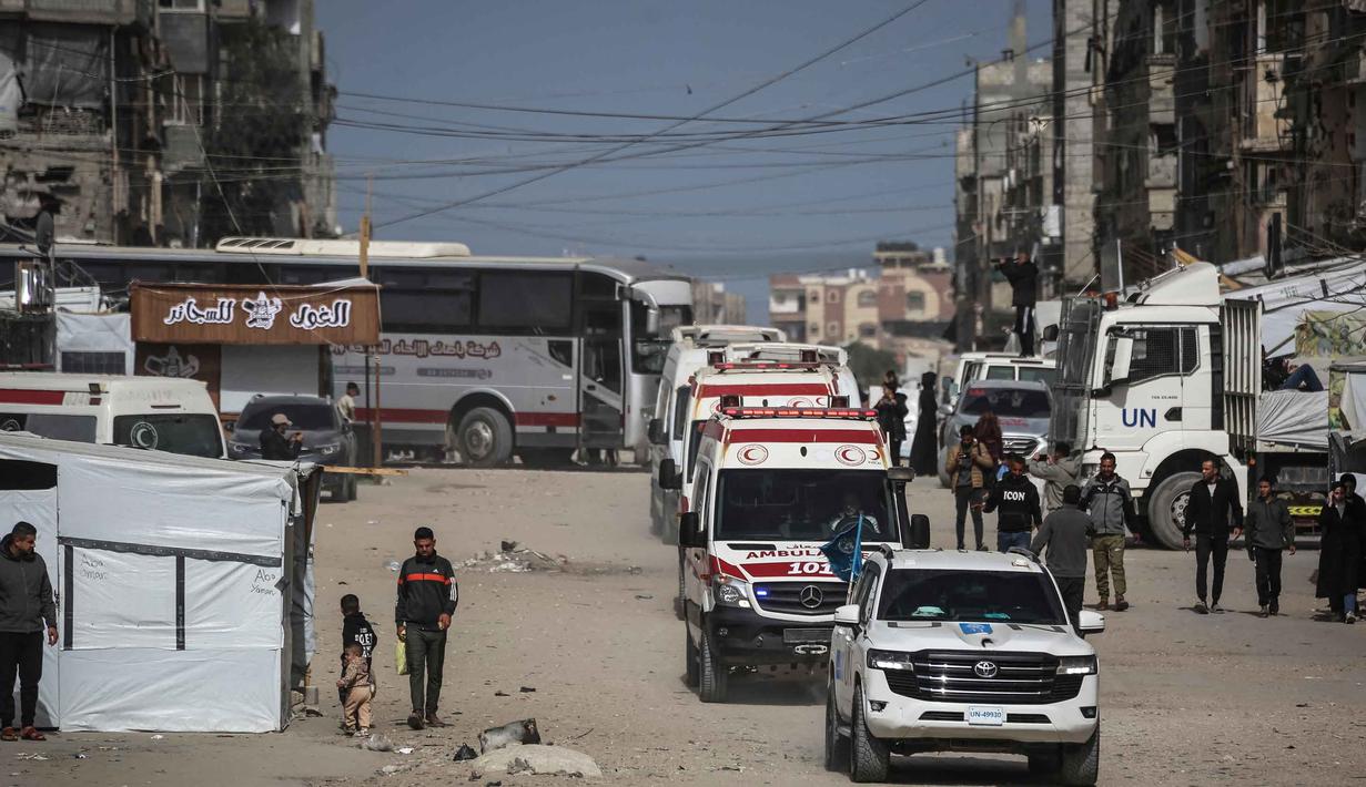 Pembukaan ini ditujukan terutama bagi pasien medis yang membutuhkan perawatan di luar negeri, pemegang paspor asing, dan pelajar. Tampak dalam foto, konvoi yang mengangkut warga Palestina menuju penyeberangan perbatasan Rafah dengan Mesir setelah dibuka untuk pertama kalinya sejak perang AS-Israel dengan Iran dimulai, di Khan Yunis pada 19 Maret 2026. (Bashar TALEB/AFP)