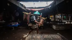 Seorang pria dari masyarakat adat Bonokeling berjalan melewati pasar selama prosesi tradisi Unggah-unggahan di Banyumas, Jawa Tengah, pada 20 Februari 2025. (DEVI RAHMAN/AFP)