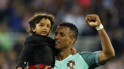 Pemain Portugal, Luis Nani merayakan kemenangan Portugal atas Prancis bersama anaknya  usai meraih trofi juara Piala Eropa 2016 di  Stade de France, Saint-Denis, Prancis, (10/7/2016). Portugal menang atas Prancis 1-0. (REUTERS/Gonzalo Fuentes)