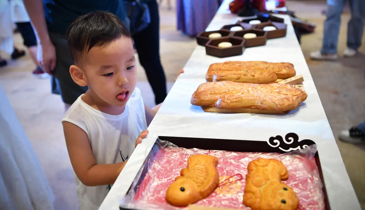 Seorang anak melihat pameran kue bulan dalam perayaan Festival Pertengahan Musim Gugur di Museum Hainan di Haikou, ibu kota Provinsi Hainan, 1 Oktober 2020. Masyarakat di seluruh China menikmati beragam makanan lezat selama libur Hari Nasional dan Festival Pertengahan Musim Gugur. (Xinhua/Guo Cheng)
