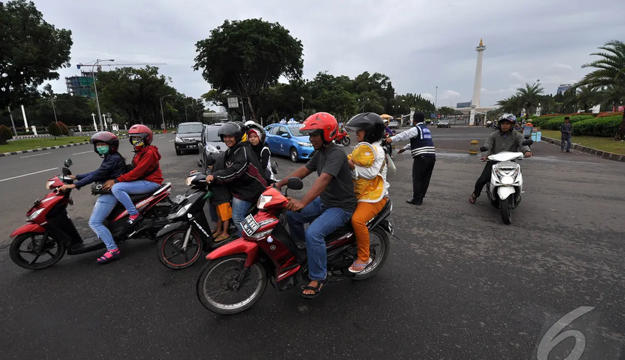 Masih banyakpengendara roda dua yang akan melintasi Jalan Merdeka Barat untuk memasuki kawasan Monas meskipun  larangan melintas untuk roda dua sudah diberlakukan, Jakarta, Kamis (1/1/2015). ( Liputan6.com/Miftahul Hayat)