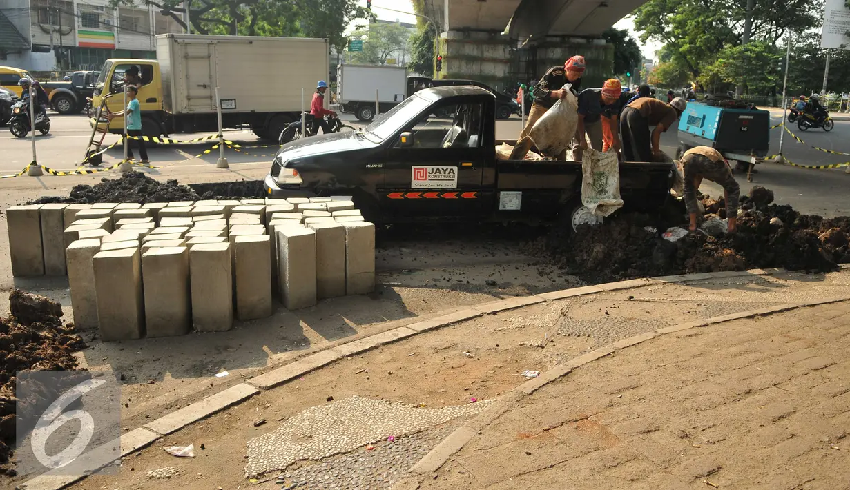 Pekerja tengah mempersiapkan meterial untuk membuat trotoar di Tanah Abang, Jakarta, Senin (18/7). Pemprov DKI tengah berupaya membuat trotoar yang ramah bagi penyandang disabilitas. (Liputan6.com/Gempur M Surya)