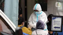 Petugas memeriksa pasien COVID-19 yang akan diantarkan ke RSDC Wisma Atlet di Puskesmas Kecamatan Tebet, Jakarta, Kamis (3/2/2022). Kasus COVID-19 sepekan terakhir mencapai 56.000 atau meningkat 40 kali lipat dibandingkan awal Januari lalu. (Liputan6.com/Herman Zakharia)