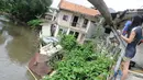 Kondisi bangunan rumah yang amblas akibat longsor di bantaran Kali Ciliwung, Kelurahan Bidara Cina, Jakarta Timur, Senin (19/3). Bangunan tersebut amblas karena erosi berkepanjangan pada tanah di bawahnya. (Liputan6.com/Herman Zakharia)