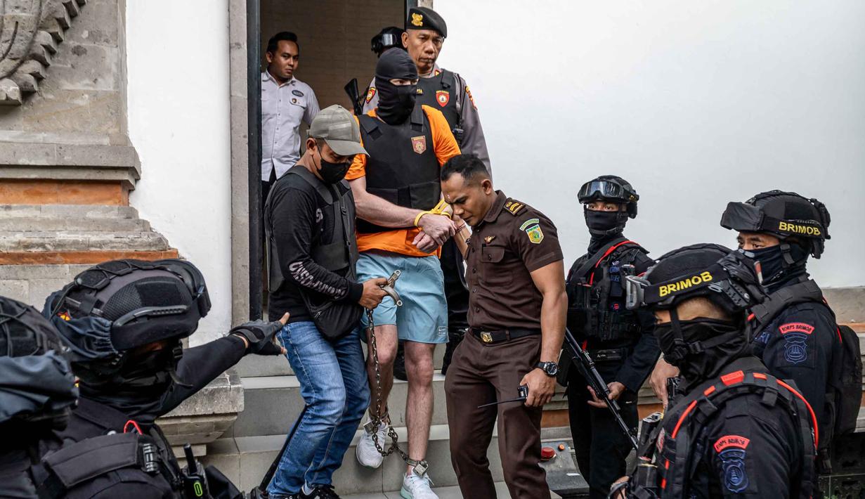 Salah satu tersangka kasus pembunuhan berencana terhadap warga negara Australia yaitu Zivan Radmanovic dan korban luka Sanar Ghanim, Darcy Francesco Jenson (tengah) dibawa kembali ke rumah tahanan setelah menjalani pemeriksaan oleh pihak kejaksaan di Badung, Bali, pada 15 Oktober 2025. (Dicky Bisinglasi/AFP)