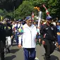 Menteri Komunikasi dan Informatika, Rudiantara (tengah) berlari membawa obor saat kirab obor Asian Games 2018 mengelilingi Kota Bogor, Jawa Barat, Selasa (14/8). Kota Bogor menjadi kota terakhir kegiatan pawai obor Asian Games. (Merdeka.com/Arie Basuki)