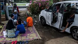 Sejumlah pemudik menggelar tikar beristirahat di rest area Tol Timur - Palimanan - Kanci,  Cirebon, Jawa Barat, Sabtu (1/7). Mereka memanfaatkan rest area untuk beristirahat sebelum meneneruskan perjalanan kembali ke Jakarta. (Liputan6.com/Faizal Fanani)