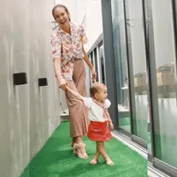 Di sini Nadi Djiwa Anggara berpose menggandeng sang ibu dengan outfit serasi. Di potret gemas ini, Nadine tampak mengenakan kemeja bermotif floral dengan nuansa warna palet dan pleats pants berwarna cokelat yang senada. Nuansa OOTD dari sang buah hati juga tampak senada dengan atasan berwarna putih, dipadu rok berwarna merah, diberi sentuhan mini syal yang dililitkan di bagian kerah. Foto: Instagram.