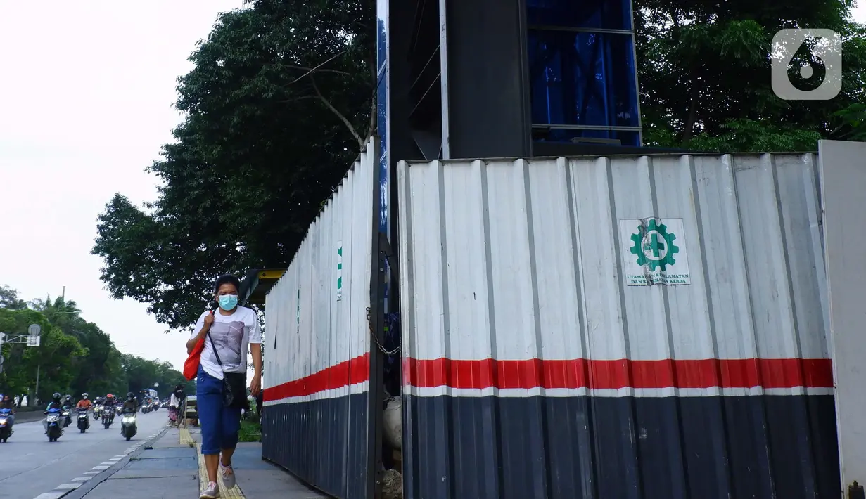 Pejalan kaki melintas di dekat lift JPO yang terbengkalai di Jalan Jembatan Gantung, Daan Mogot, Jakarta Barat, Rabu (17/3/2021).  Fasilitas lift ini sangat disayangkan tidak dipergunakan terlebih malah dipergunakan sebagai tempat tinggal warga. (Liputan6.com/Johan Tallo)