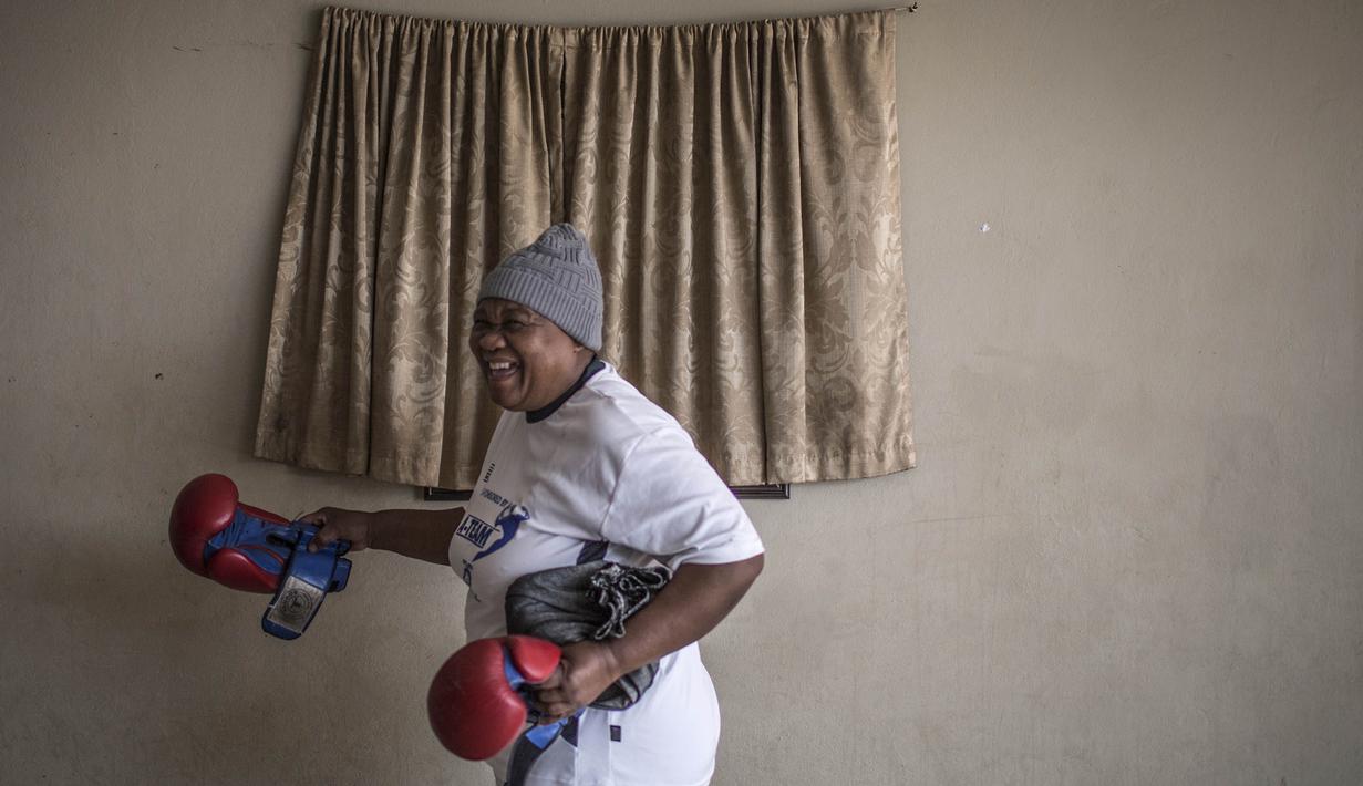 Seorang nenek usai berlatih tinju pada Boxing Gogos di Cosmo City, Johannesburg, Selasa (19/9/2017). Berkat latihan rutin yang dipimpin Claude Maphosa ini para lansia berhasil sembuh dari penyakit dan hidup lebih sehat. (AFP/Gulshan Khan) 