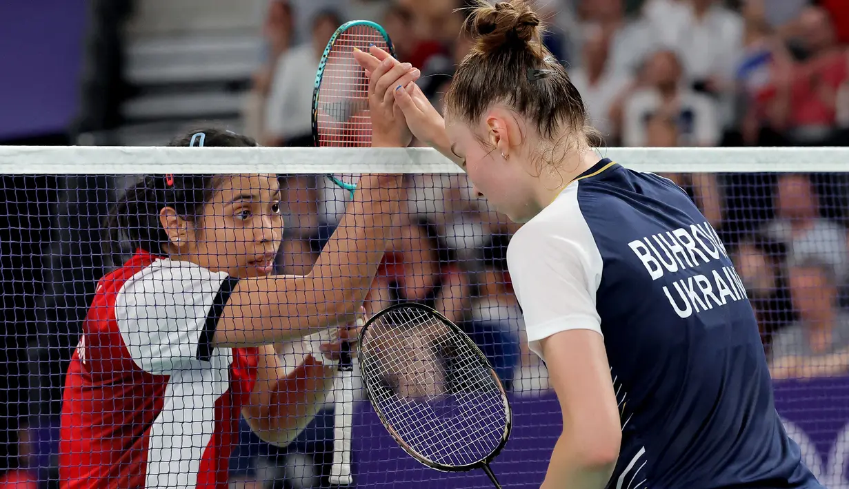 <p>Pemain tunggal putri Indonesia, Gregoria Mariska Tunjung menyalami dan berusaha menghibur lawannya, wakil Ukraina Polina Buhrova setelah berakhirnya laga Grup G bulu tangkis Olimpiade Paris 2024 di Porte de la Chapelle Arena, Prancis, Minggu (28/7/2024). Gregoria Mariska Tunjung menang straight game 21-10, 21-15. (AFP/David Gray)</p>