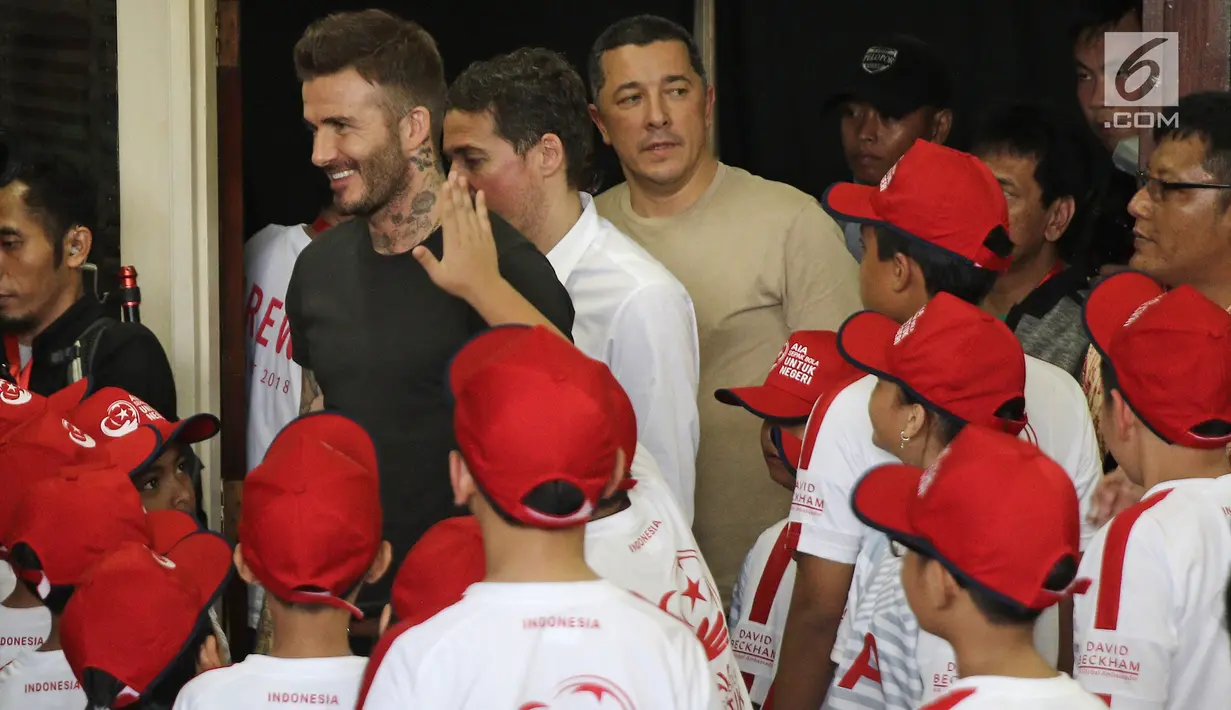 Mantan bintang sepak bola Inggris David Beckham menyapa anak-anak pada acara AIA Sepak Bola untuk Negeri di Jakarta, Minggu (25/3). Kegiatan David dan AIA yaitu membagikan 10 ribu bola untuk akademi sepak bola di Indonesia. (Liputan6.com/Herman Zakharia)