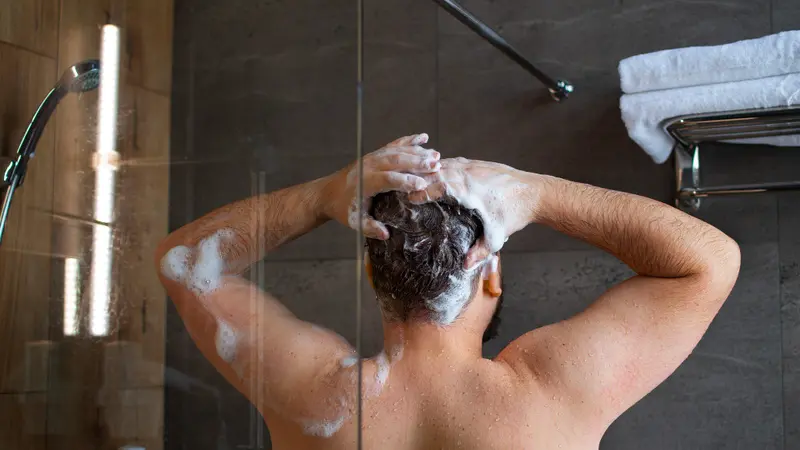 Ilustrasi cowok mencuci rambut dengan shampo