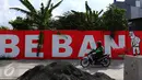 Pengendara motor melintasi mural bernuansa politik di Penjaringan, Jakarta, Minggu (7/8). Pesan-pesan yang disampaikan oleh mural politik ini biasanya bercermin dari kegiatan politik di Indonesia saat ini. (Liputan6.com/Angga Yuniar)
