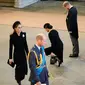 Kate Middleton (kiri), Pangeran William (ke-2 dari kiri), Meghan Markle (ke-2 dari kanan), dan Pangeran Harry (kanan) memberi penghormatan di dalam Westminster Hall di Istana Westminster, tempat peti mati Ratu Elizabeth II dibaringkan pada 14 September 2022. (Christopher Furlong/POOL/AFP)