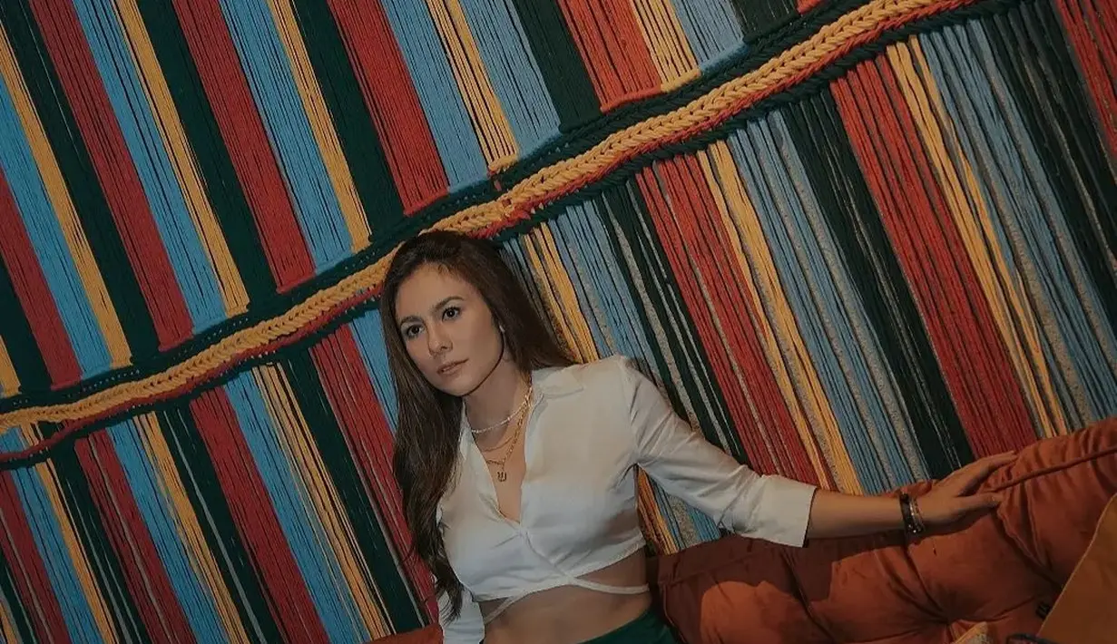 Wulan Guritno tidak hanya mengenakan crop top untuk tampilan kasual. Ia pun mengenakan kemeja satin crop untuk tampil formal dengan celana berwarna hijau emerald. [instagram/wulanguritno]