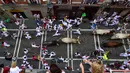 Peserta bersuka ria berlari di dekat banteng selama Festival San Fermin di Pamplona, Spanyol, Senin (9/7). Festival San Fermin berlangsung selama delapan hari. (AP Photo/Alvaro Barrientos)