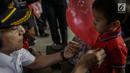 Petugas PT KAI Daop 1 memberikan pin garuda kepada penumpang di Stasiun Gambir, Jakarta, Kamis (1/6). Dalam rangka memperingati HUT Pancasila PT KAI Daop 1 memberikan pin dan bendera merah putih kepada penumpang kereta api. (Liputan6.com/Faizal Fanani)