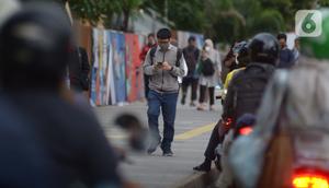 Karyawan perkantoran berjalan kaki  bergegas pulang di Kawasan Sudirman, Jakarta, Rabu (30/11/2022). Keputusan Pemerintah Provinsi (Pemprov) DKI Jakarta menaikan upah minimum provinsi (UMP) DKI  pada 2023 sebesar 5.6 persen menjadi Rp 4,9 juta . ditolak pengusaha dan buruh. (merdeka.com/Imam Buhori)