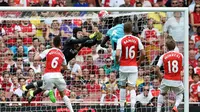 Cheikhou Kouyate menaklukkan kiper Arsenal, Petr Cech, untuk mencetak gol pertama West Ham dalam pertandingan di Stadion Emirates, London. Minggu (9/8/2015). (Action Images via Reuters/Tony O'Brien)