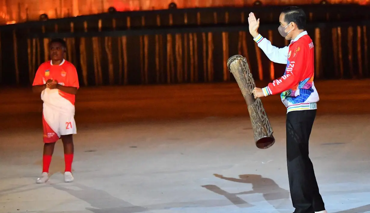 Presiden Joko Widodo (kanan) memukul alat musik tifa saat Upacara PON XX Papua di Stadion Lukas Enembe Kabupaten Jayapura, Sabtu (2/10/2021). PON XX Papua ini diikuti oleh 34 kontingen dengan jumlah atlet mencapai 7.039 atlet. (Foto:Tangkapan Layar YouTube Sekretariat Presiden)