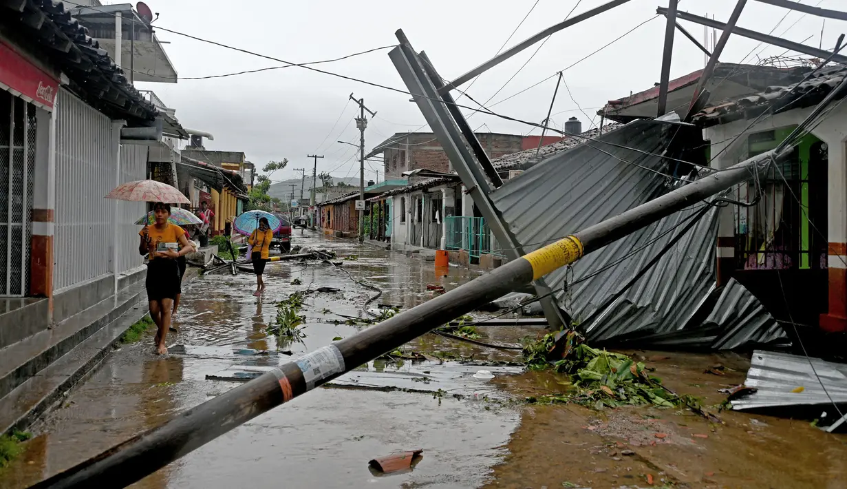 Sekelompok wanita berjalan melewati kerusakan di sebuah jalan akibat Badai John di San Marcos, Negara Bagian Guerrero, Meksiko, pada tanggal 24 September 2024. (Francisco Robles/AFP)
