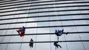 Tokoh superhero Captain America dan Superman membersihkan kaca jendela kamar di rumah sakit anak-anak di Guadalupe, Meksiko, 30 April 2019. Mereka bergelantungan di luar jendela dengan mengenakan kostum superhero untuk menghibur anak- anak yang sedang sakit. (REUTERS/Daniel Becerril)