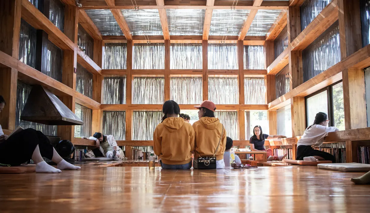 Dalam gambar pada 15 September 2018, orang-orang membaca di Perpustakaan Liyuan, pinggiran kota Beijing. Sayangnya, pemilik perpustakaan melarang pengunjung mengambil foto di dalam ruangan. (FRED DUFOUR/AFP)