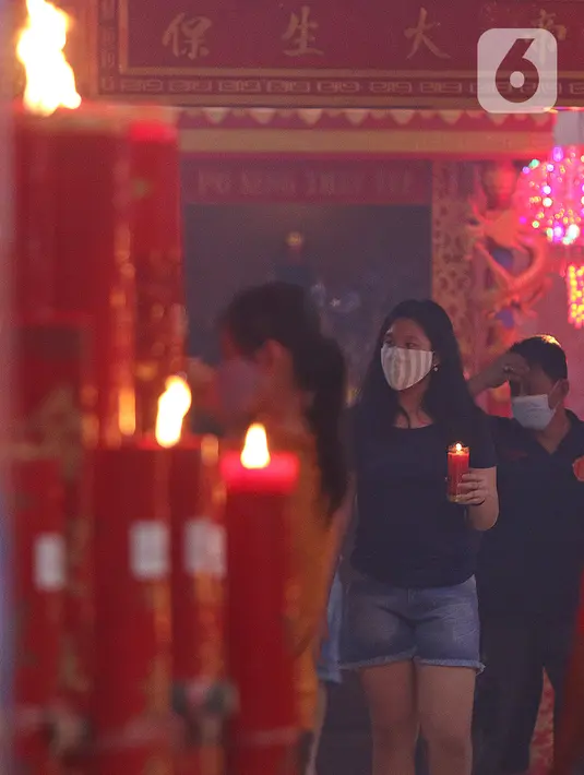 Warga keturunan Tionghoa membawa lilin di Klenteng Hok Lay Kiong, Bekasi, Jawa Barat, Kamis (11/2/2021). Sembahyang di malam Imlek ini sebagai ungkapan syukur atas rezeki dan keselamatan dari Tuhan serta untuk pengharapan kehidupan lebih baik di tahun Kerbau. (Liputan6.com/Herman Zakharia)