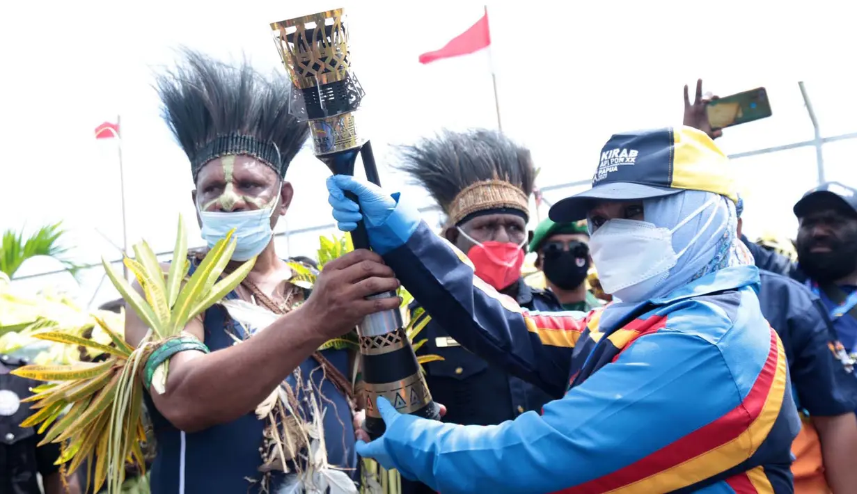 Mantan Atlit Tenis Meja Rossy Pratiwi Syechbubakar (kanan) memberikan api obor kepada petugas pembawa obor di Bandara Mapoh Merauke Papua, Kamis (30/09/2021).(FOTO PB PON XX PAPUA/Setiyo Sc)