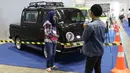 Pengunjung berpose dengan kendaraan yang dipajang dalam pameran Indonesia Classic N Unique Bus 2019 di JIExpo Kemayoran, Jakarta, Rabu (20/3). Pameran ini merangkai sejarah transportasi di Indonesia. (Liputan6.com/Immanuel Antonius)