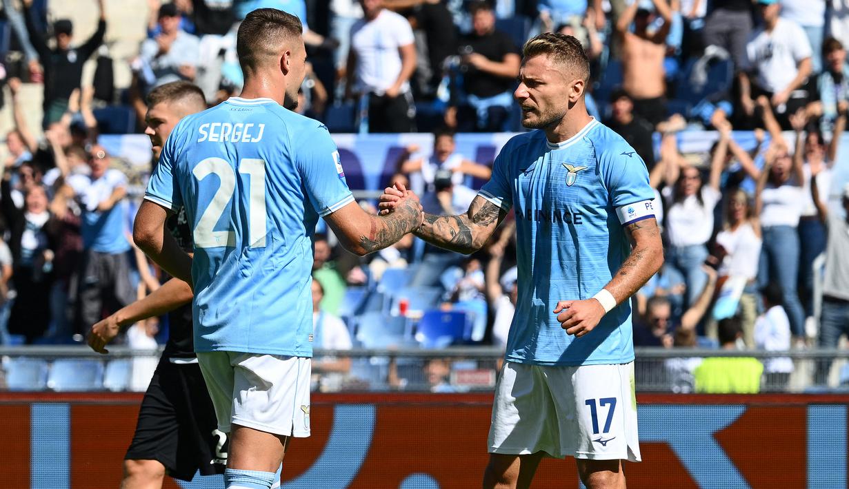 Ciro Immobile dan Sergej Milinkovic-Savic. Duet Lazio, Ciro Immobile dan Sergej Milinkovic-Savic total menyumbang 38 gol di Liga Italia pada musim 2021/2022. Rinciannya adalah Sergej Milinkovic-Savic mencetak 11 gol dan 11 assist, sementara penyerang asal Italia, Ciro Immobile total membukukan 27 gol dan 3 assist. (AFP/Vincenzo Pinto)
