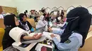 Petugas memeriksa kesehatan calon haji setibanya di Asrama Haji Pondok Gede, Jakarta, Selasa (21/4/2026). Sebanyak 393 jemaah haji kelompok terbang (kloter) pertama embarkasi Jakarta-Pondok Gede (JKG 01) secara resmi mulai memasuki Asrama Haji Pondok Gede, Jakarta Timur. (merdeka.com/Arie Basuki)