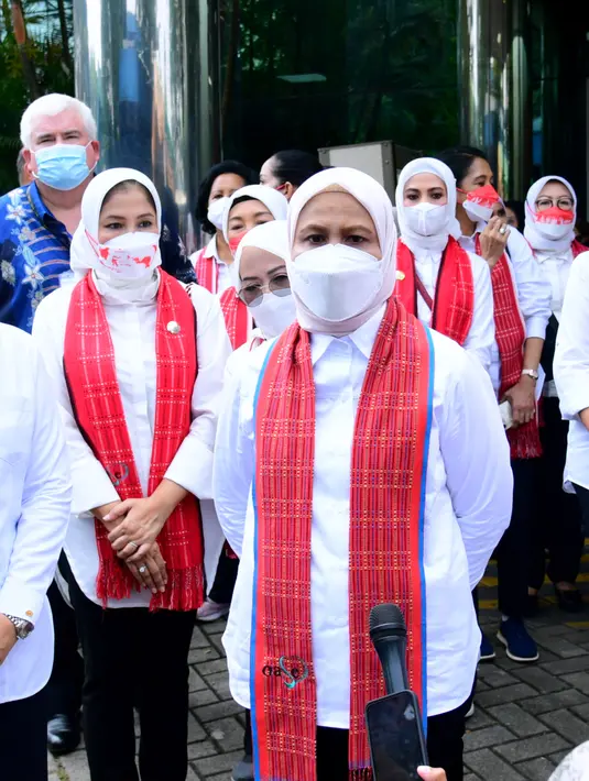Melakukan kunjungan bersama ibu Wury Ma'ruf Amin, Iriana Jokowi mengenakan kemeja putih lengan panjang dan celana hitam. Ia pun menyematkan kain tenun berwarna merah sebagai aksen yang cantik. (Sekretariat Presiden)