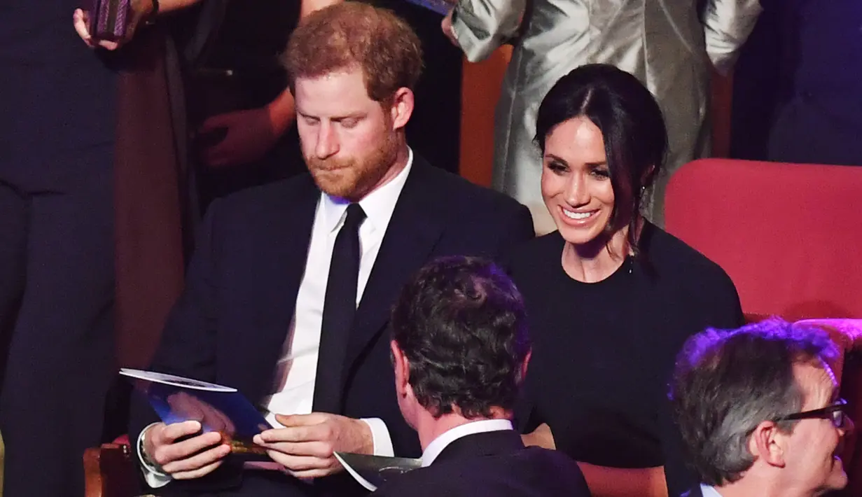Pangeran Harry bersama tunangannya, Meghan Markle menghadiri konser perayaan ulang tahun Ratu Elizabeth di London, Sabtu (21/4). Penampilan Meghan Markle terlihat serasi dengan busana yang dikenakan Pangeran Harry. (ANDREW PARSONS/POOL/AFP)