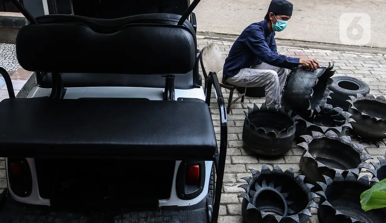 Abdul Kholik menyelesaikan pembuatan pot bunga dari ban bekas di Galeri Abdul Kholik, Tapos, Depok, Jumat (30/10/2020). Kerajinan pot bunga dari limbah ban bekas mobil Boogie Car atau mobil golf itu dijual seharga Rp75 ribu hingga Rp100 ribu tergantung warna dan ukuran. (Liputan6.com/Johan Tallo)