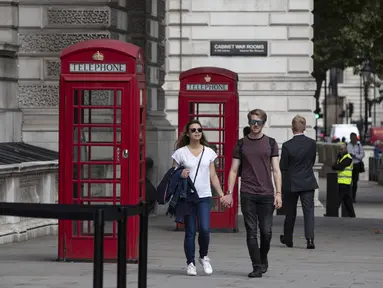 Orang-orang berjalan melewati bilik telepon umum di pusat Kota London, Inggris (8/9/2020). Angka resmi terbaru Inggris pada Selasa (8/9) menunjukkan bahwa korban meninggal akibat COVID-19 di negara tersebut telah mencapai 57.400. (Xinhua/Han Yan)