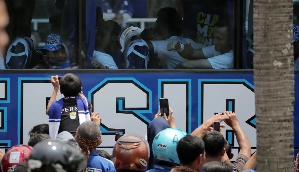 Aksi Suporter cilik memotret Pemain Persib Bandung saat ditemani orang tua pada acara parade  Juara Piala Presiden 2015 di Kota Baru, Bandung, Minggu (25/10/2015). (Bola.com / Nicklas Hanoatubun)