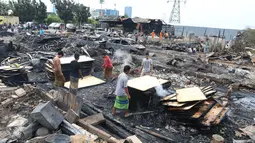 Sejumlah warga sedang mencari sisa puing yang masih bisa digunakan dari kebakaran yang menghanguskan lapak kayu di kawasan Rawa Buaya, Jakarta Barat, Rabu (4/1). Sebanyak 15 lapak kayu dan 6 mobil hangus terbakar. (Liputan6.com/Angga Yuniar)