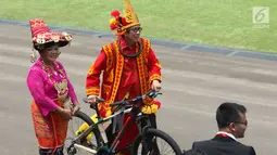 Menkumham, Yasonna H Laoly membawa hadiah sepeda dari Presiden Jokowi usai peringatan HUT RI ke 72 di Istana Merdeka, Jakarta, Kamis (17/8). Yasonna mengenakan pakaian adat Nias saat perayaan Hari Kemerdekaan Indonesia. (Liputan6.com/Pool)