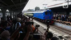 Warga menyaksikan rangkaian lokomotif listrik ESS 3200 tahun pembuatan 1927 saat memasuki peron pada perayaan 100 tahun operasional Kereta Rel Listrik (KRL) di Stasiun Jakarta Kota, Selasa (22/4/2025). (Liputan6.com/Angga Yuniar)