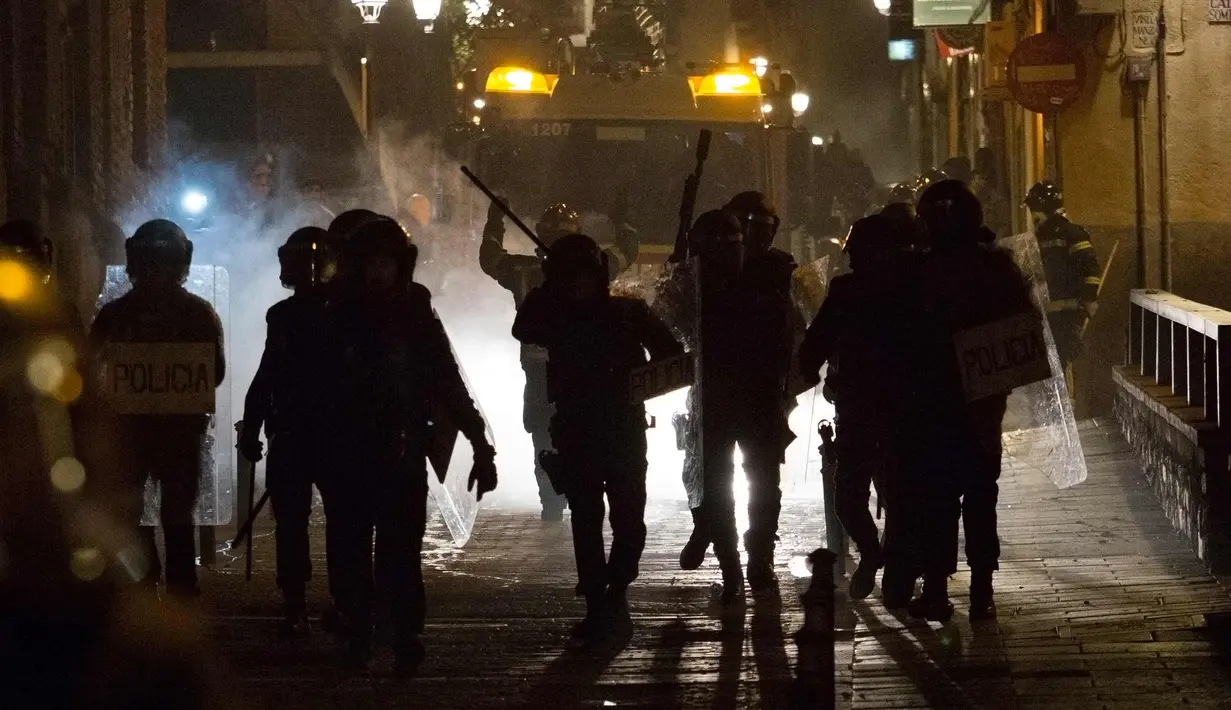 Petugas polisi saat terlibat bentrok dengan imigran di Madrid, Spanyol, Kamis (15/3). Bentrokan berawal dari aksi protes imigran atas meninggalnya seorang pedagang jalanan asal Senegal. (AFP Photo/Olmo Calvo)
