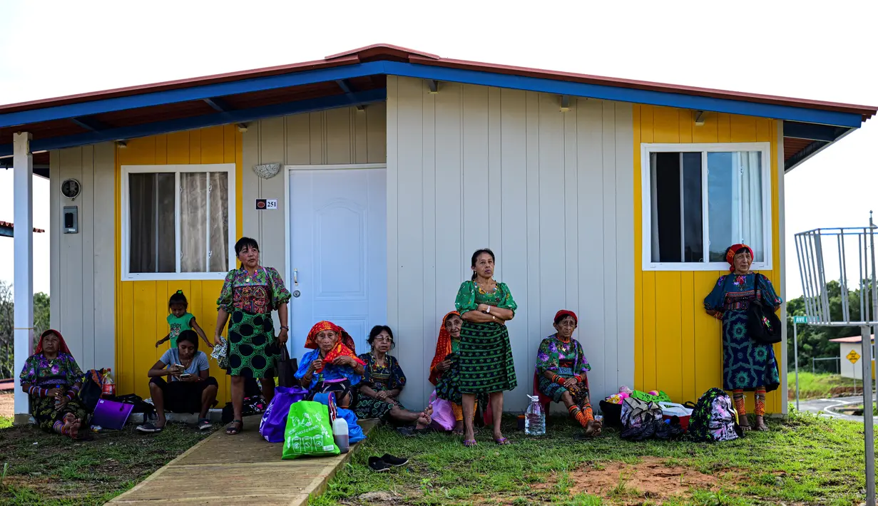 Masyarakat adat Gunas menunggu di luar rumah baru mereka di Nuevo Carti, Guna Yala Comarca, di pantai Karibia di daratan Panama, pada 29 Mei 2024. (MARTIN BERNETTI / AFP)