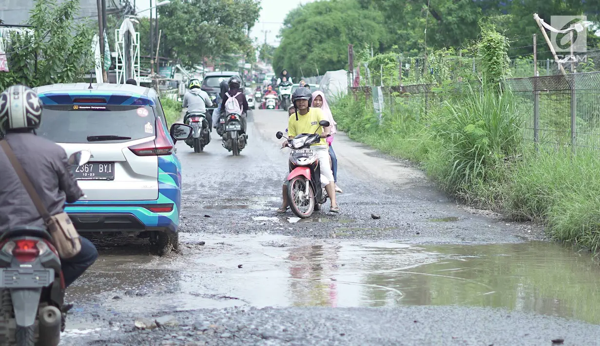 Kendaraan melintasi jalan yang rusak di Jalan Raya Gas Alam, Depok, Jawa Barat, Selasa (7/5). Kondisi jalan yang tidak kunjung diperbaiki tersebut menjadi kubangan air setiap hujan serta berbahaya bagi keselamatan pengguna jalan. (Liputan6.com/Immanuel Antonius)