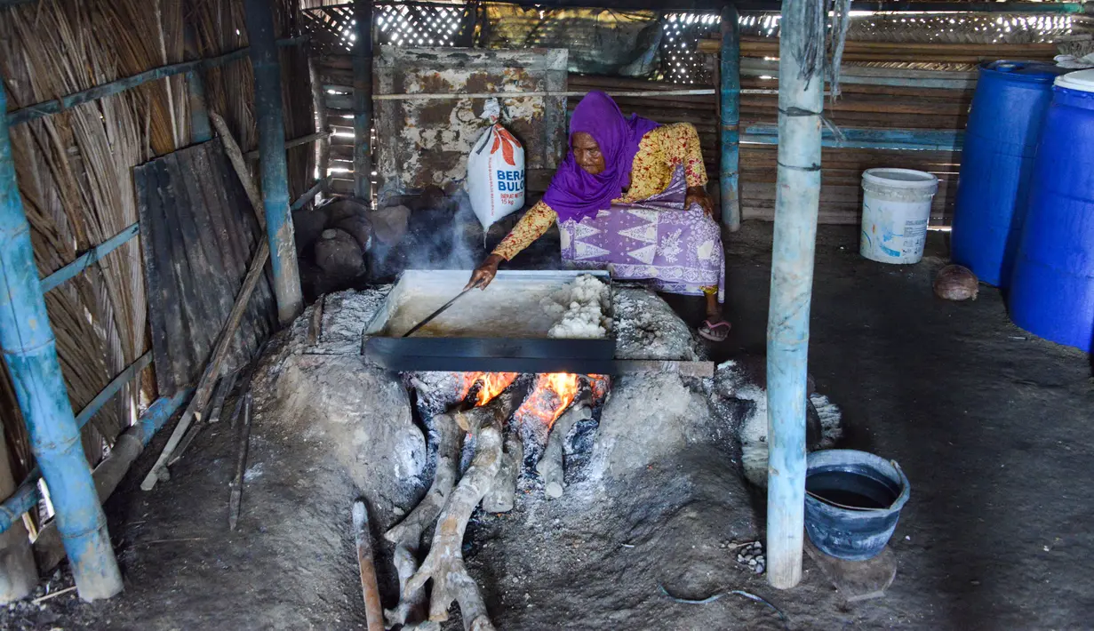 Perempuan petani tradisional mengumpulkan garam yang telah masak di Lampanah, Aceh, 26 Agustus 2019. Setiap petani di permukiman Lampanah mampu memproduksi garam sekitar 150 - 200 kg per hari yang dijual Rp5.000 per kg. (CHAIDEER MAHYUDDIN / AFP)