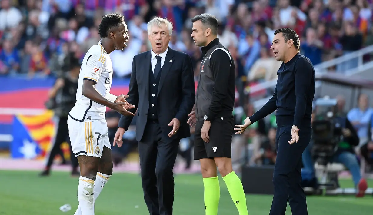 Pada babak pertama, Vinicius Junior juga kedapatan adu mulut dengan pelatih Barcelona, Xavi Hernandez. Protes tersebut dilayangkan Vinicius setelah dirinya dilanggar oleh pemain Barcelona namun wasit tidak memberikan pelanggaran untuk dirinya. (AFP/Josep Lago)