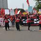 Massa buruh berjalan menuju Istana Negara saat aksi Hari Buruh di Jakarta, Senin (1/5). Dalam aksinya para buruh meminta sistem kerja kontrak dan upah rendah dihapus. (Liputan6.com/Helmi Afandi)