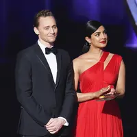 Meski baru saja putus cinta, Tom Heddleston tetap terlihat baik-baik saja saat berada di atas panggung bersama Pryanka Chopra. Beberapa kali ia terlihat melempar senyum dan terlihat romantis bersama Pryanka. (AFP/Bintang.com)