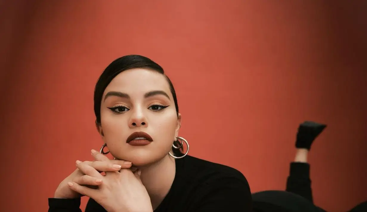 Vibe lady boss dari Selena Gomez. Outfit hitamnnya dipadu dengan makeup bold dan lipstik merah. [Foto: Instagram/selenagomez]